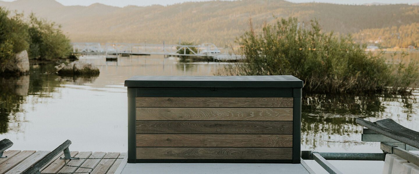 Woman grabbing cushions from Keter deck box