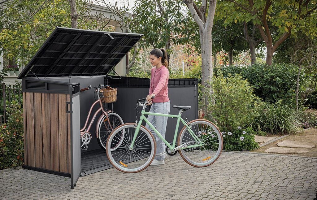 Femme rangeant son vélo dans un abri de jardin horizontal