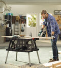 Man in garage fixing motorcycle using Stack N Roll tool storage system