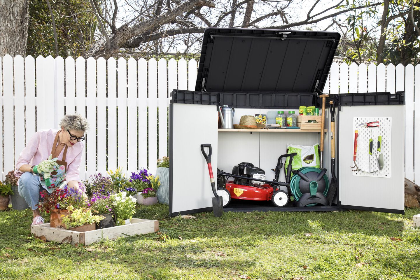 Lady gardening next to her open Premier XL grey storage shed showing organisation options 