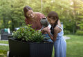mother and daughter water their plants together in the Keter Easy Grow garden bed