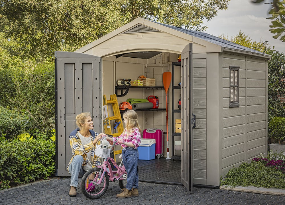 Mom and daughter taking a bike out of a storage shed