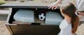 keter brown deck box with baseball bats, cushions and a soccer ball