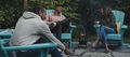 Three people sitting on Keter adirondack chairs in the backyard