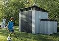 a young boy kicks around a soccer ball in front of Keter sheds