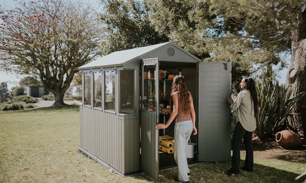 green potting shed with two women walking in