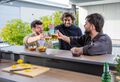 3 male friends having a drink in a bar shed