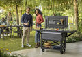 Man and woman grab a drink together form their Keter Patio Cooler while outside on their patio during a party  