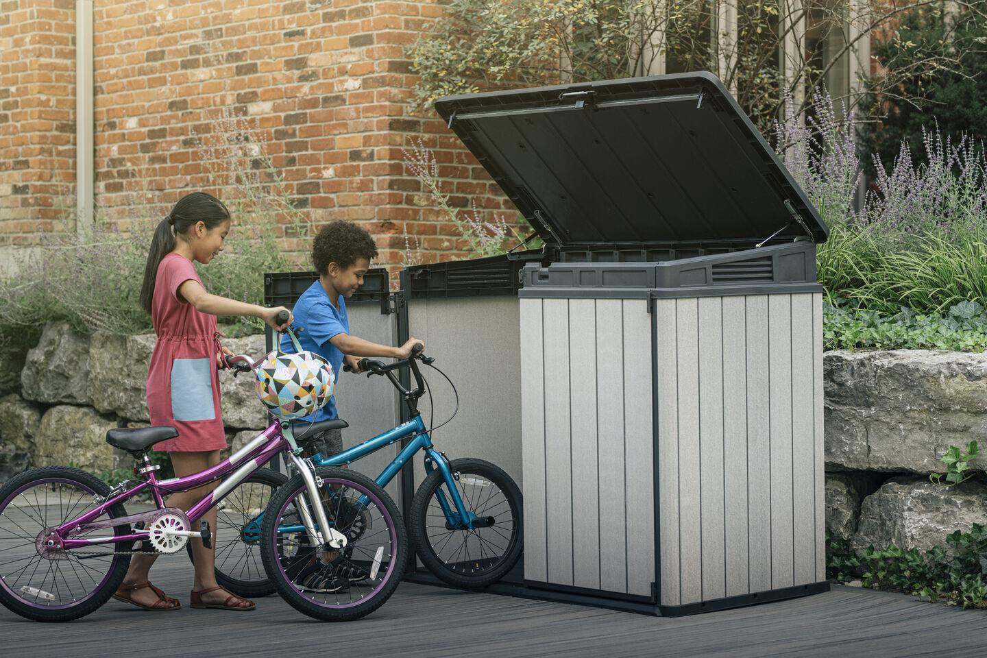 Kids storing their bikes into a shed