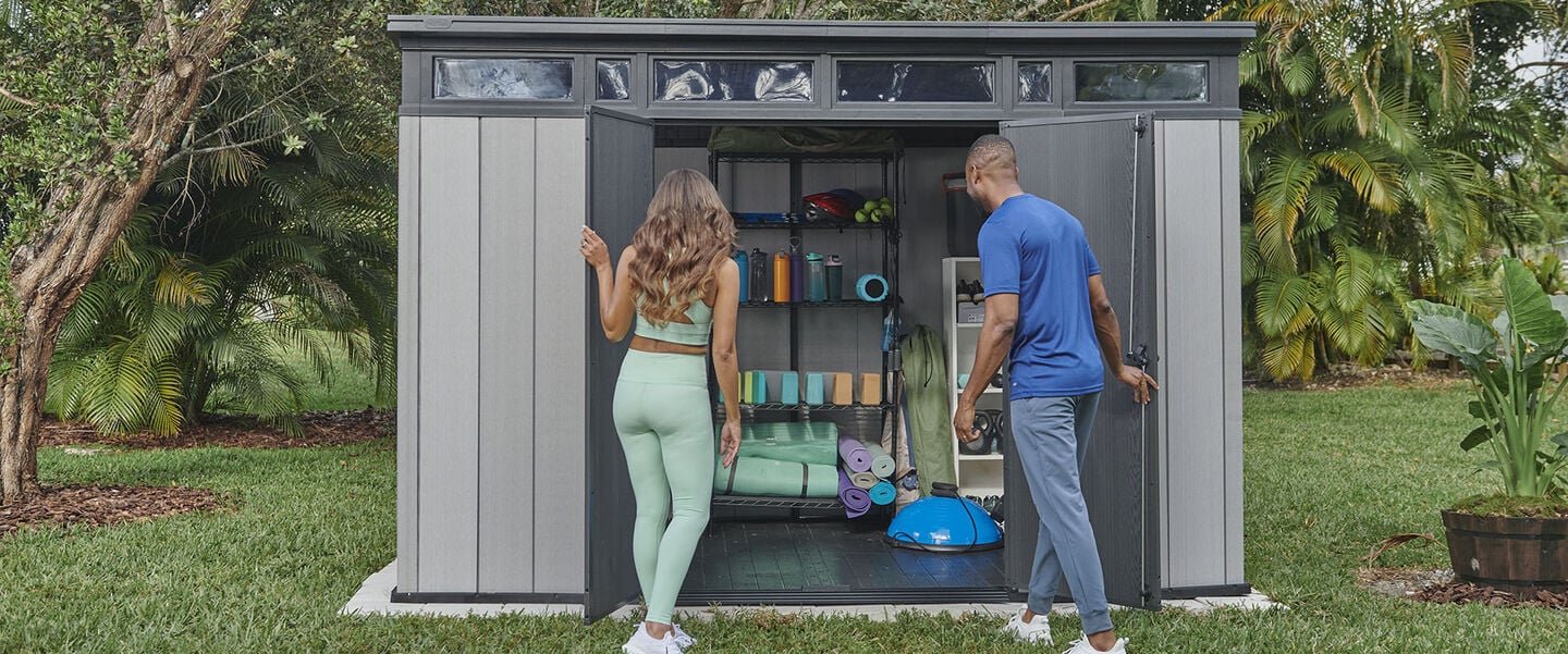Fitness couple looking for exercise equipment in a storage shed