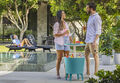 a man and woman are grabbing a drink around a Keter Cool Bar next to a pool
