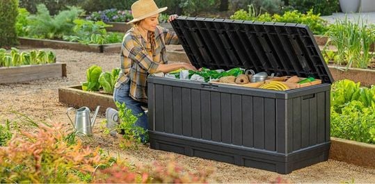 woman opening a deck box with gardening items inside