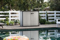the Patio Store storage shed cabinet sits by the pool