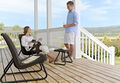 woman sitting on her rio patio set on her balcony talking to her husband