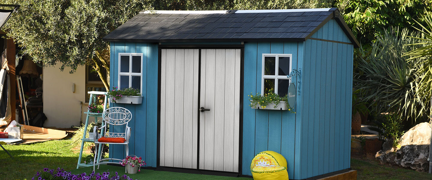 Blue and white storage shed in a backyard
