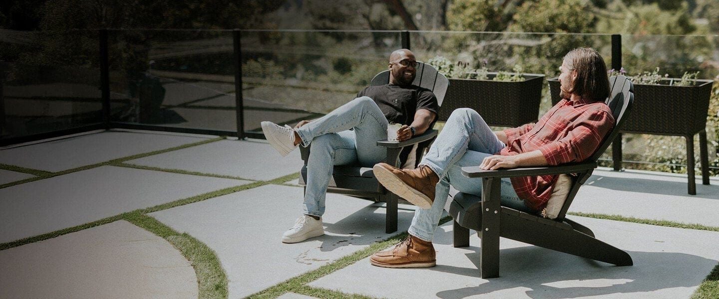 two men seating on an adirondack chair