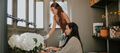Two women potting plants inside keter potting shed