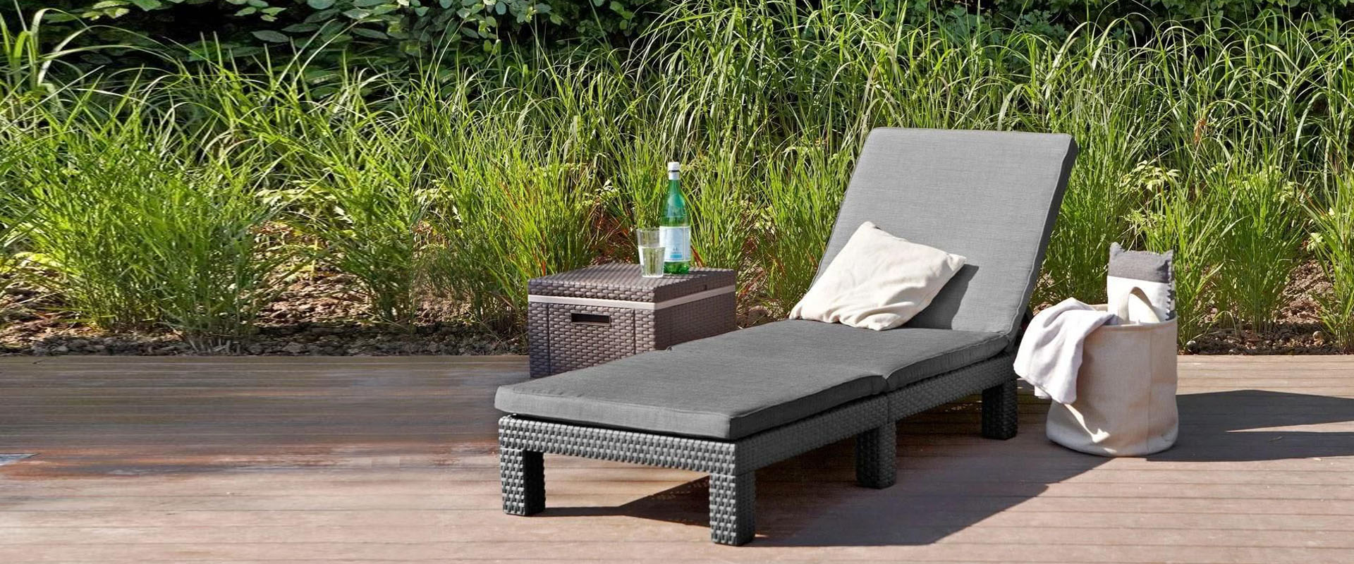 Chaise longue et table basse devant verdure