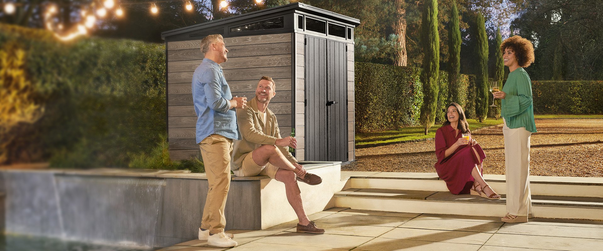 Friends Entertaining in a garden featuring a Keter shed