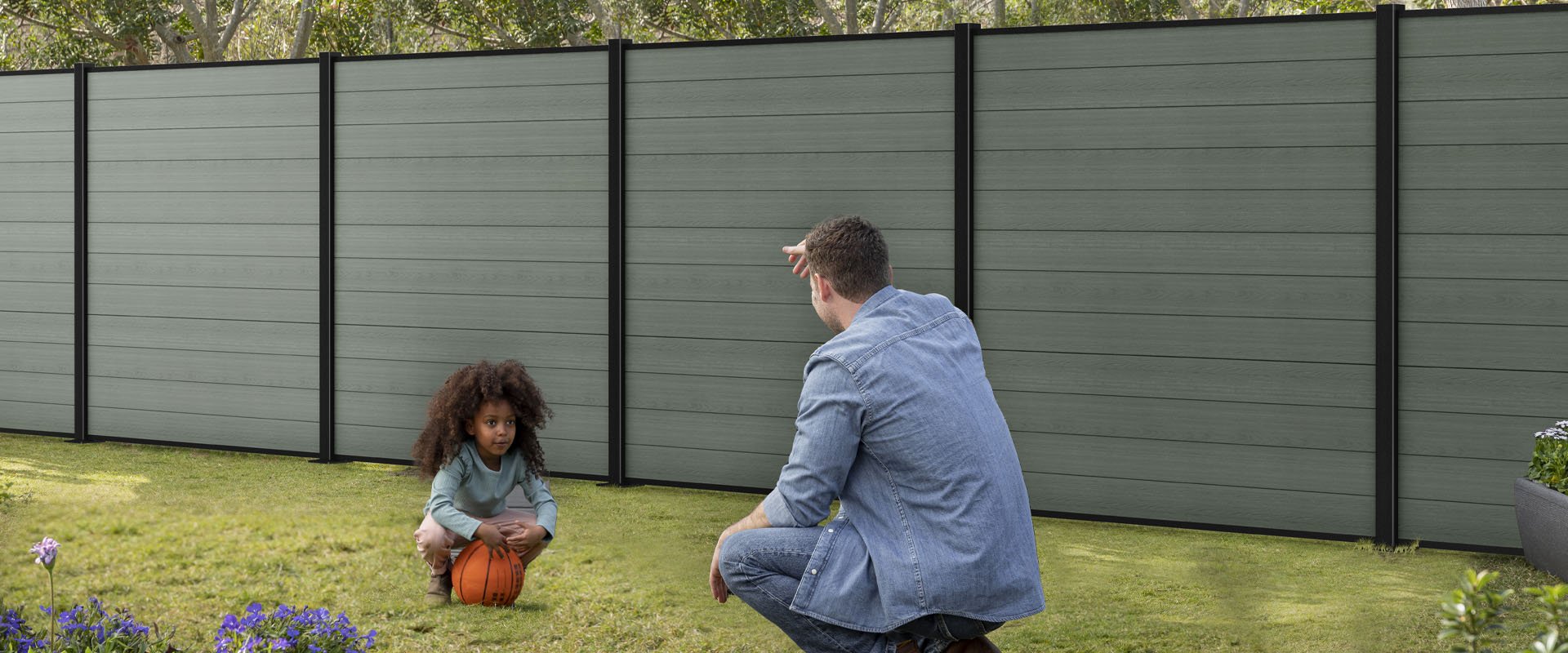 Father and daughter playing ball next to Keter fencing