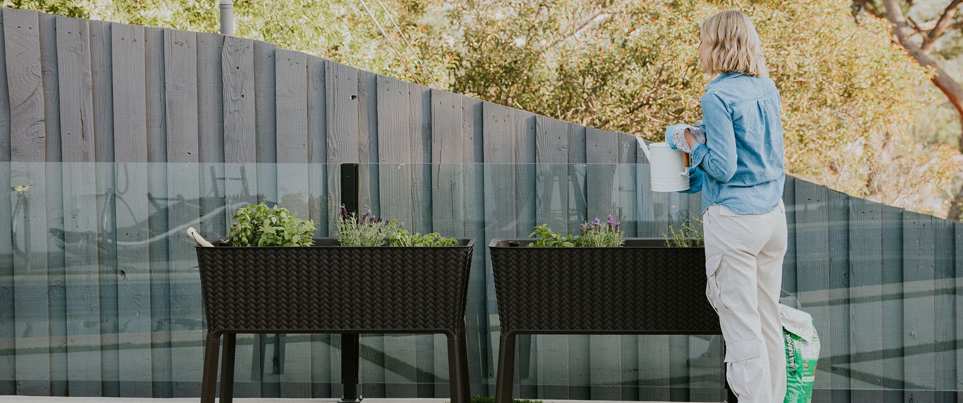 woman gardens in her raised garden bed by Keter