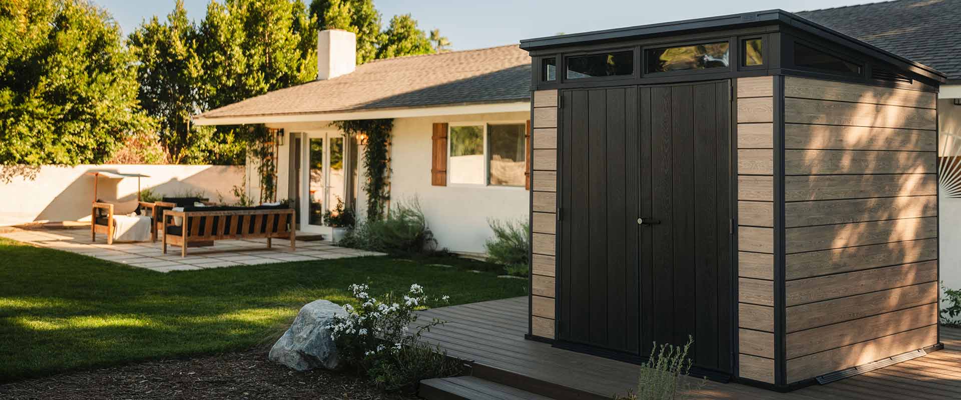 Keter Signature 7x7 Shed in Ashwood Brown in a backyard