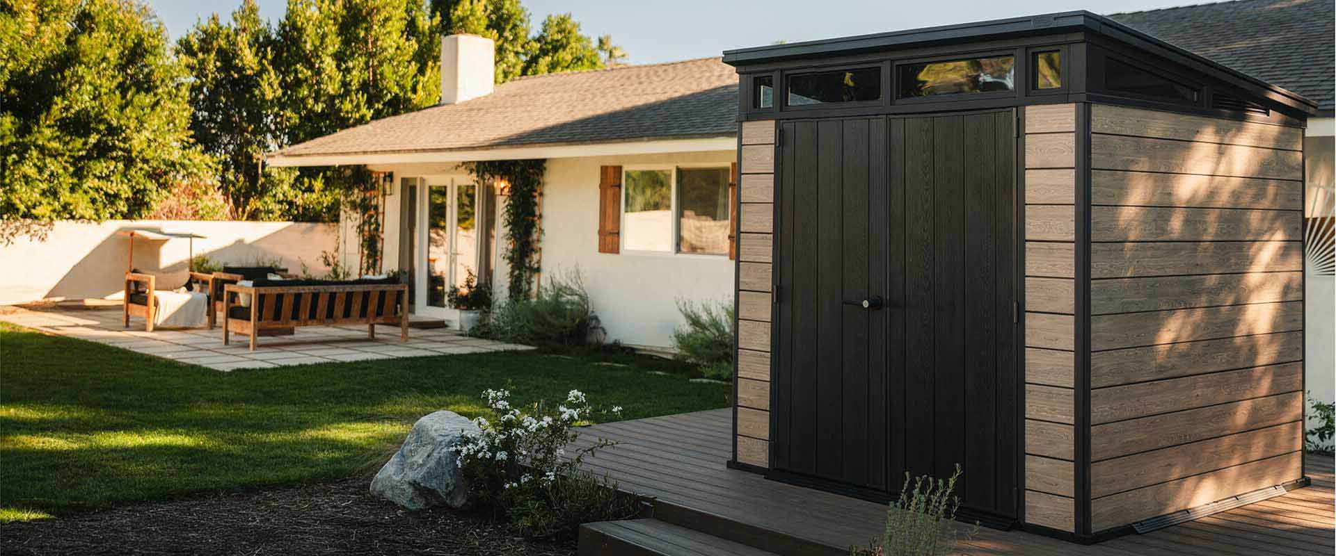Keter Signature 7x7 Shed in Ashwood Brown in a backyard